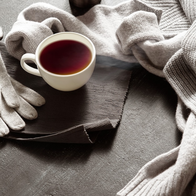 Vestiti caldi e una tazza di tè nelle giornate autunnali o invernali. Spazio per il testo