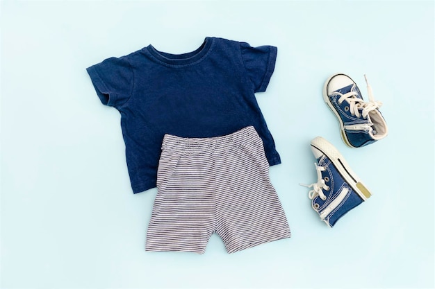 Vestiti e accessori estivi per bambini blu con t-shirt pantaloncini da ginnastica Outfit per bambini alla moda moderna Set di abbigliamento per bambini per la primavera o l'estate Flat lay top viewoverheadmockup