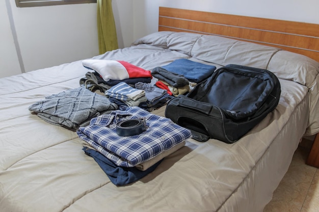 Vestiti e valigia sul letto preparati per un viaggio