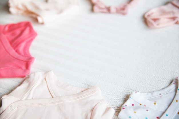 Vestiti per bambini su sfondo di tessuto pastello chiaro Delicato umore morbido e accogliente