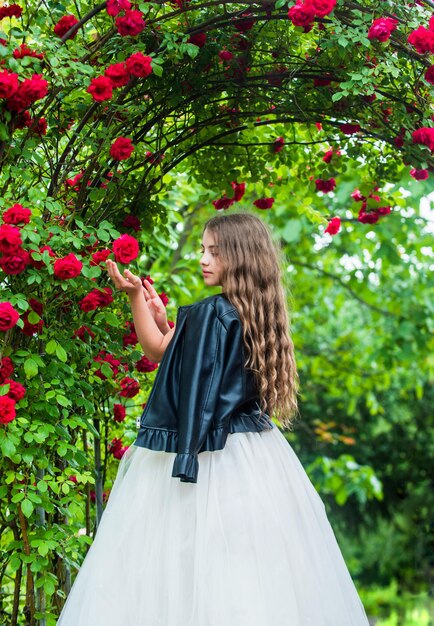 Vestito elegante da ragazza alla moda e giacca di pelle nel concetto di collezione brutale del giardino delle rose