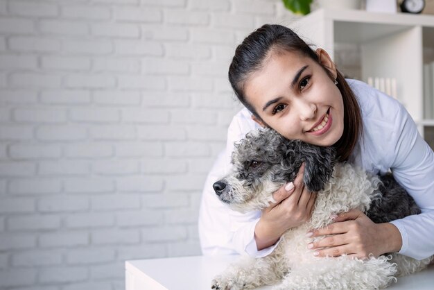 Veterinario sorridente che esamina e abbraccia un cane di razza mista