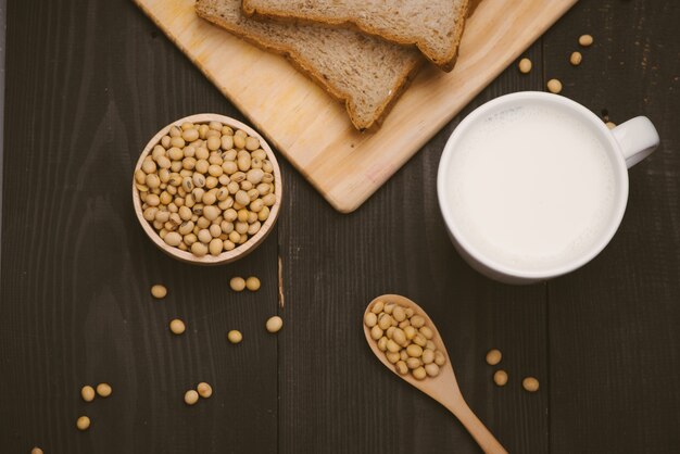 Vetro con latte di soia e fagiolo di soia su fondo di legno