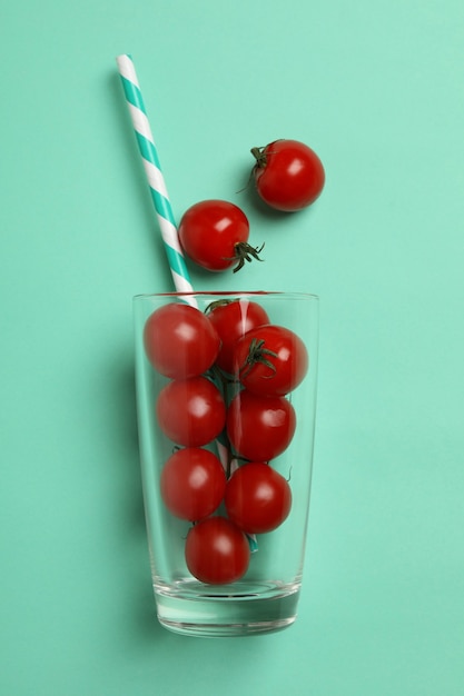 Vetro con pomodori e paglia su sfondo di menta