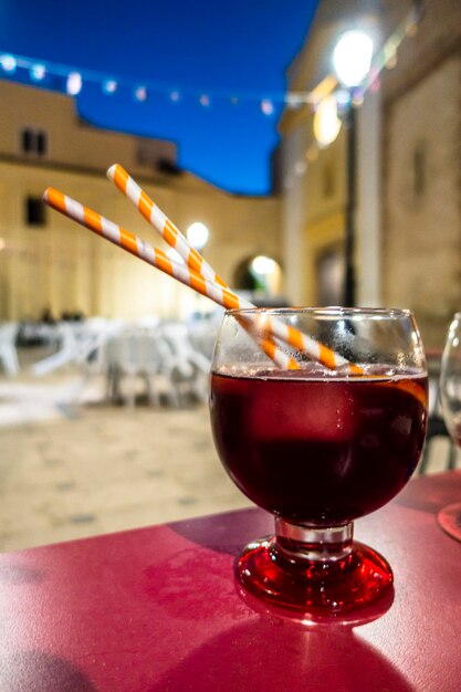 Vetro con rosso estivo su un tavolo da terrazza al tramonto