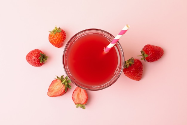 Vetro con succo di fragola fresco sul rosa