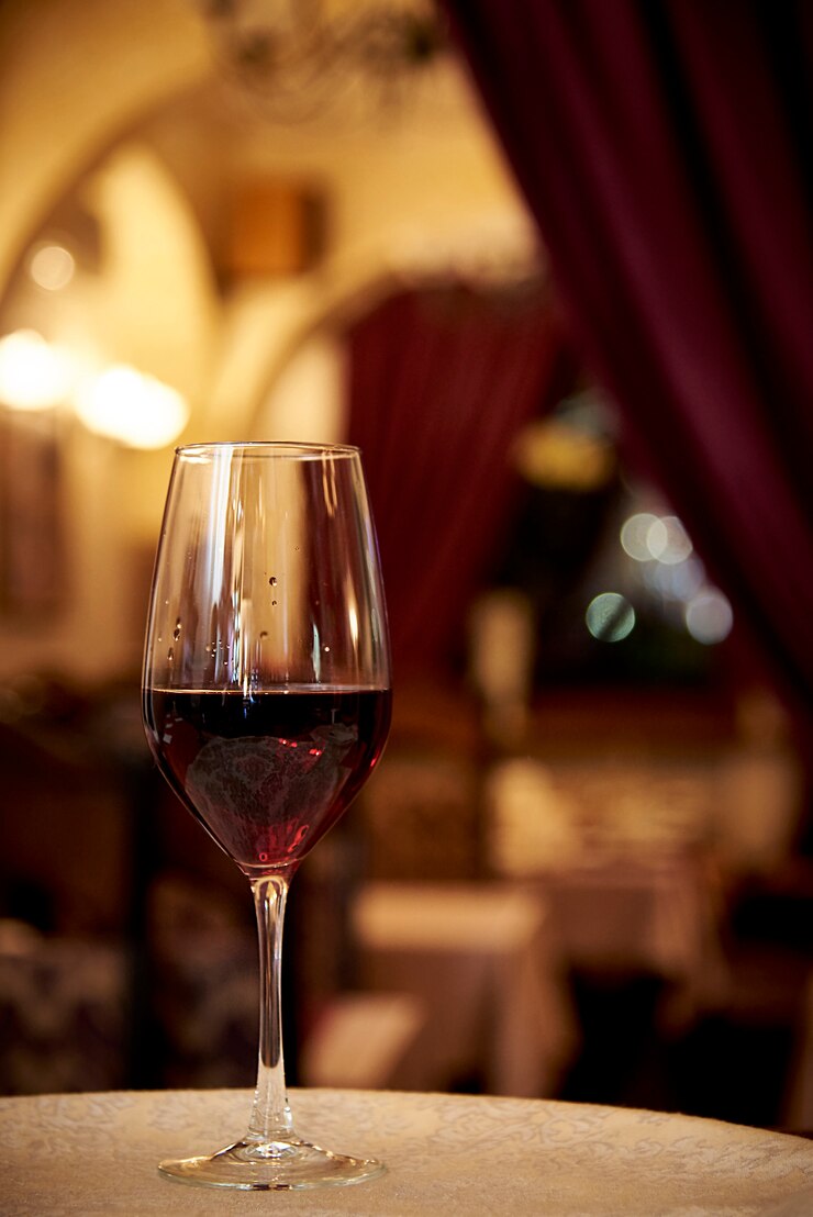 Vetro con vino rosso su uno sfondo di un ristorante sfocato