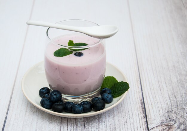 Vetro con yogurt di mirtilli su un tavolo