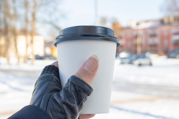 Vetro di plastica bianco con caffè sullo sfondo della città