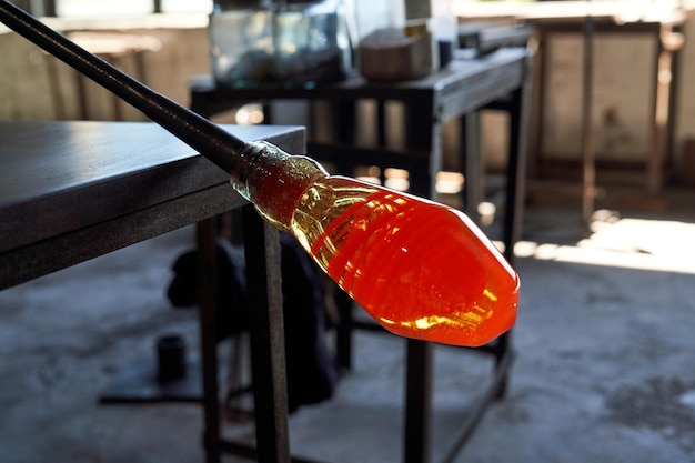 Vetro liquido riscaldato sulla punta del cannello durante il processo di realizzazione del vaso narghilè in officina