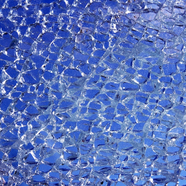 Vetro rotto incrinato su sfondo blu
