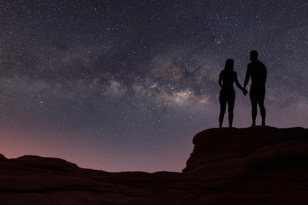 Via Lattea con silhouette di persone Paesaggio con cielo stellato notturno Uomo e donna in piedi sul