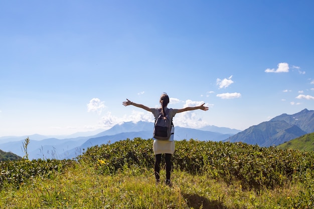 Viaggi, avventura e trekking con Escursioni in montagna. Una ragazza sta in cima a una montagna con le mani in alto.