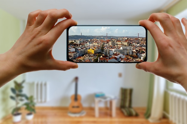 Viaggia a casa. Viaggio online a Lisbona, Portogallo tramite smartphone. Cityscape sullo schermo.