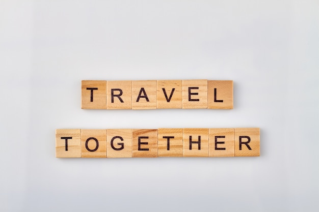 Viaggiare insieme è sempre divertente e piacevole. Blocchi di legno fatti parole su sfondo bianco.