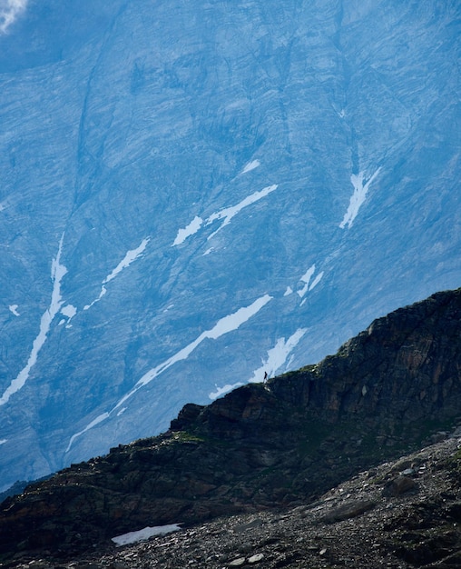 Viaggiatore che cammina giù per la montagna rocciosa