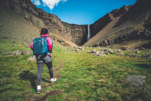 Viaggiatore che fa un'escursione alla cascata di Hengifoss, Islanda.