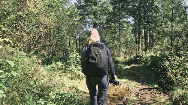 Viaggiatore che fotografa la vista panoramica nella foresta Una donna caucasica che scatta un bel look magico Ragazza scatta video fotografici su una fotocamera mirrorless dslr