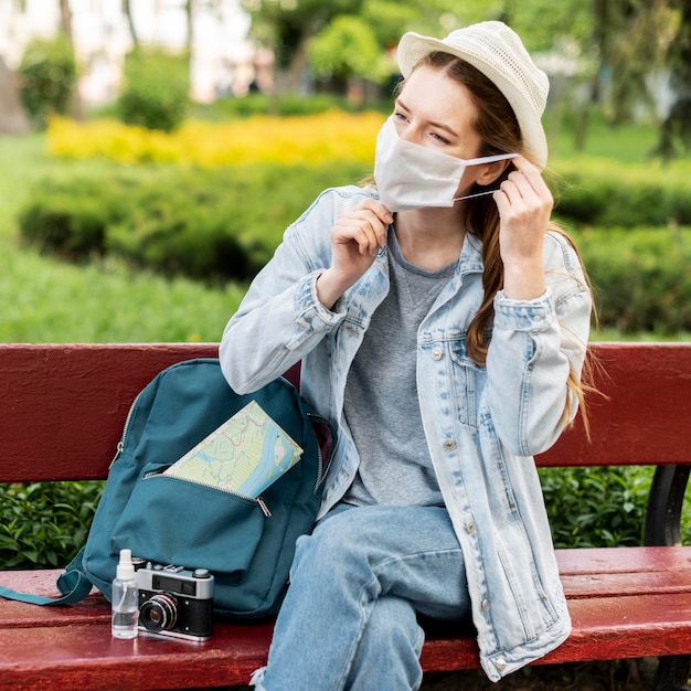 Viaggiatore che indossa maschera medica e seduta