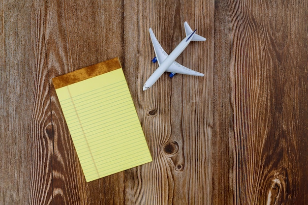 Viaggiatore con l'aeroplano di pianificazione del viaggio con note di carta bianca,