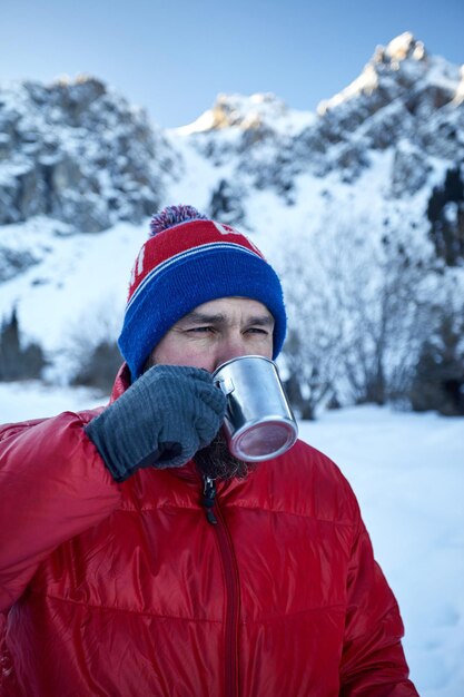 Viaggiatore con una tazza di caffè in montagna