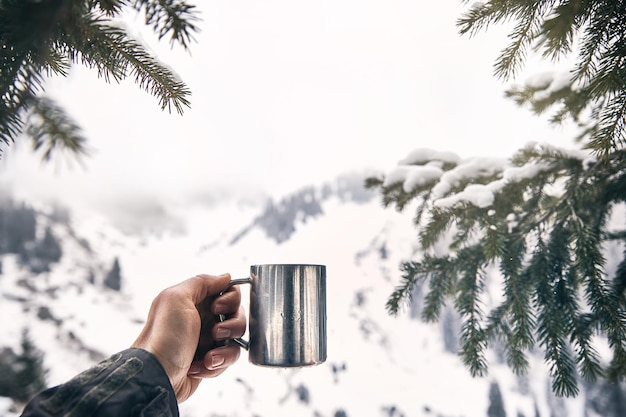 Viaggiatore con una tazza di caffè in montagna