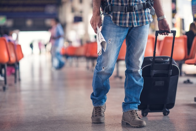 Viaggiatore con una valigia sulla stazione degli autobus