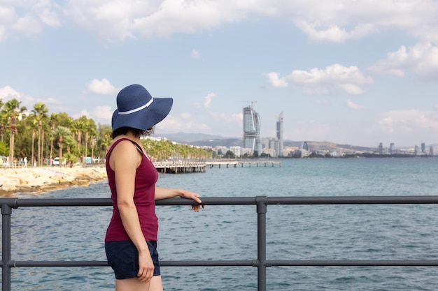 Viaggiatore della donna al paesaggio urbano moderno sulla costa del mare