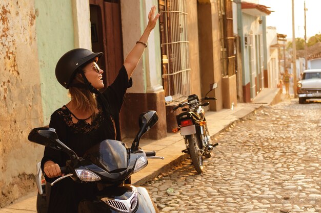 Viaggiatore della donna alla guida di scooter per le strade della città vecchia