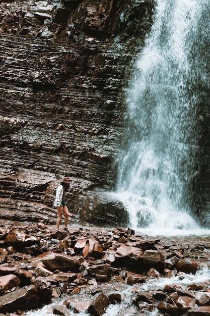 Viaggiatore della donna che gode della vista della cascata