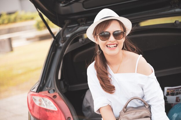 Viaggiatore della donna che si siede sull&#39;autovettura a tre oa cinque porte dell&#39;automobile