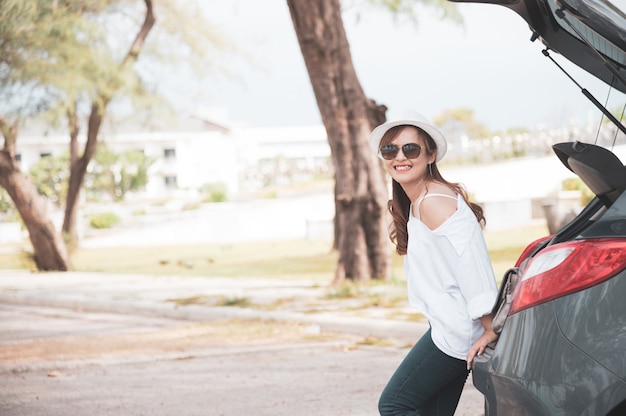 Viaggiatore della donna che si siede sull&#39;autovettura a tre oa cinque porte dell&#39;automobile