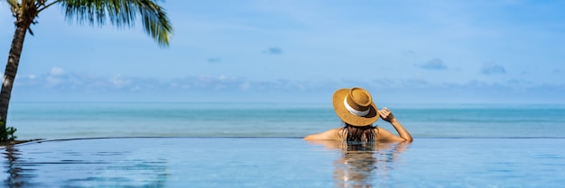 Viaggiatore della giovane donna che si rilassa e si gode da una piscina tropicale del resort durante il viaggio per le vacanze estive, concetto di viaggio