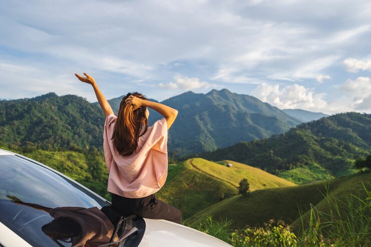 Viaggiatore della giovane donna che si siede su una macchina che guarda una bella vista sulle montagne mentre viaggia guida viaggio su strada in vacanza