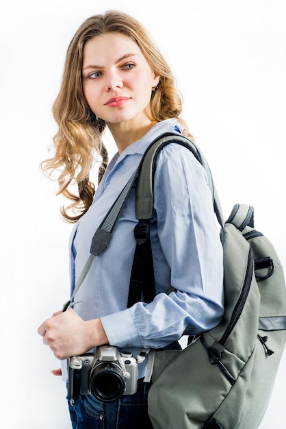 Viaggiatore della giovane donna con la macchina fotografica e lo zaino da portare su fondo bianco