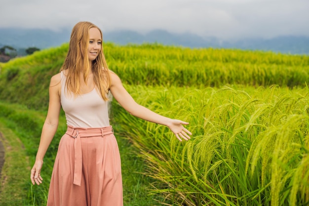 Viaggiatore della giovane donna sulle belle terrazze di riso di Jatiluwih sullo sfondo dei famosi vulcani di Bali, Indonesia