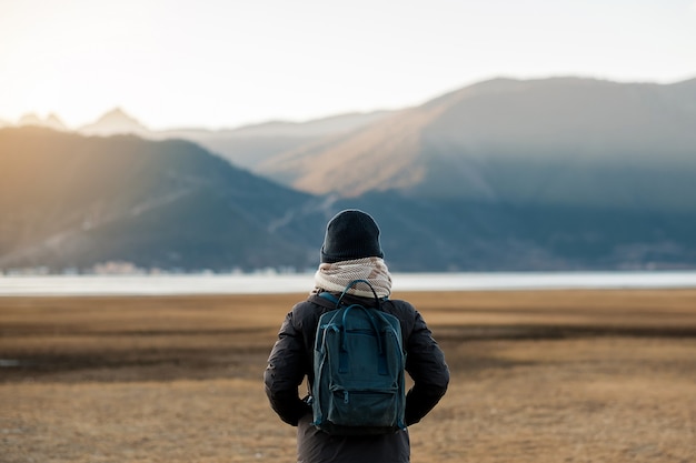 Viaggiatore di donna hipster con maglione e zaino in viaggio sul lago Napa