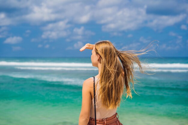 Viaggiatore di giovane donna sulla splendida spiaggia di Melasti con acque turchesi Isola di Bali Indonesia