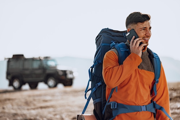 Viaggiatore di giovane uomo caucasico utilizzando il suo smartphone