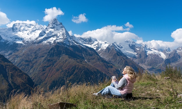 Viaggiatore donna beve caffè con vista sul paesaggio montano