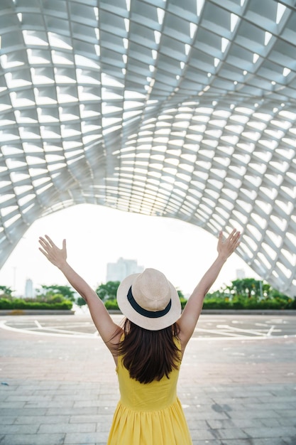 Viaggiatore donna con abito giallo in visita nella città di Da Nang Visita turistica dell'edificio della città Punto di riferimento e popolare per l'attrazione turistica Vietnam e concetto di viaggio nel sud-est asiatico