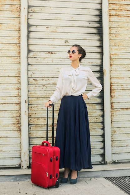 Viaggiatore elegante con bagagli rossi