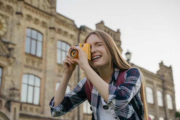 Viaggiatore felice con lo zaino che cammina sulla strada, scattare foto