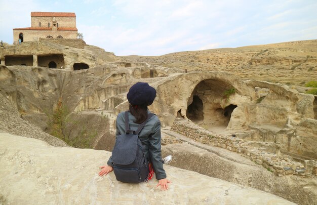 Viaggiatore femminile che ammira le rovine della città della caverna di Uplistsikhe, vicino a Gori Town in Georgia