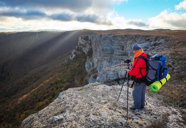 Viaggiatore fotografo naturalista che scatta foto del bellissimo paesaggio mattutino dalla cima della montagna