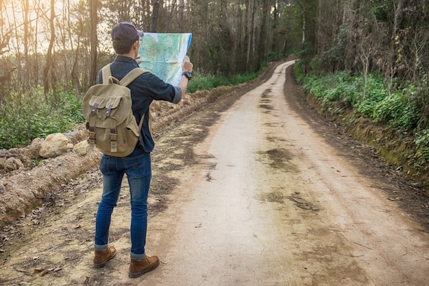 Viaggiatore giovane con zaino rilassante all&#39;aperto con le montagne rocciose sullo sfondo Vacanze estive e concetto di escursionismo Lifestyle