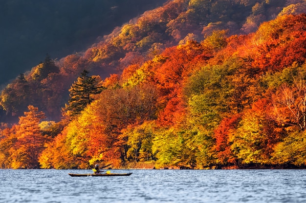 Viaggiatore indefinito che kayaking il lago con la stagione di autunno intorno al lago a Nikko, Giappone, paesaggio