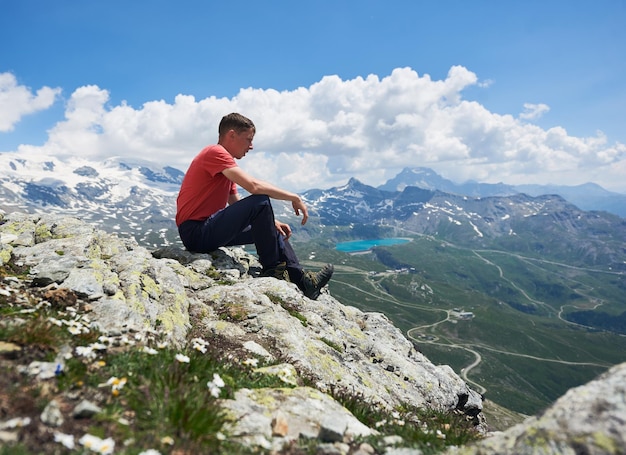 Viaggiatore maschio seduto in cima a una montagna rocciosa