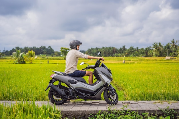 Viaggiatore maschio su una bicicletta tra un campo di riso Viaggi turistici a Bali