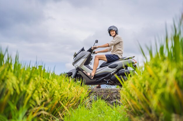 Viaggiatore maschio su una bicicletta tra un campo di riso Viaggi turistici a Bali